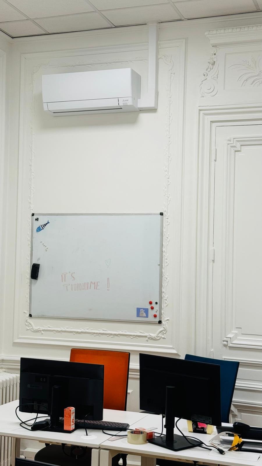 Zoom sur le split mural dans un bureau haussmannien parisien
