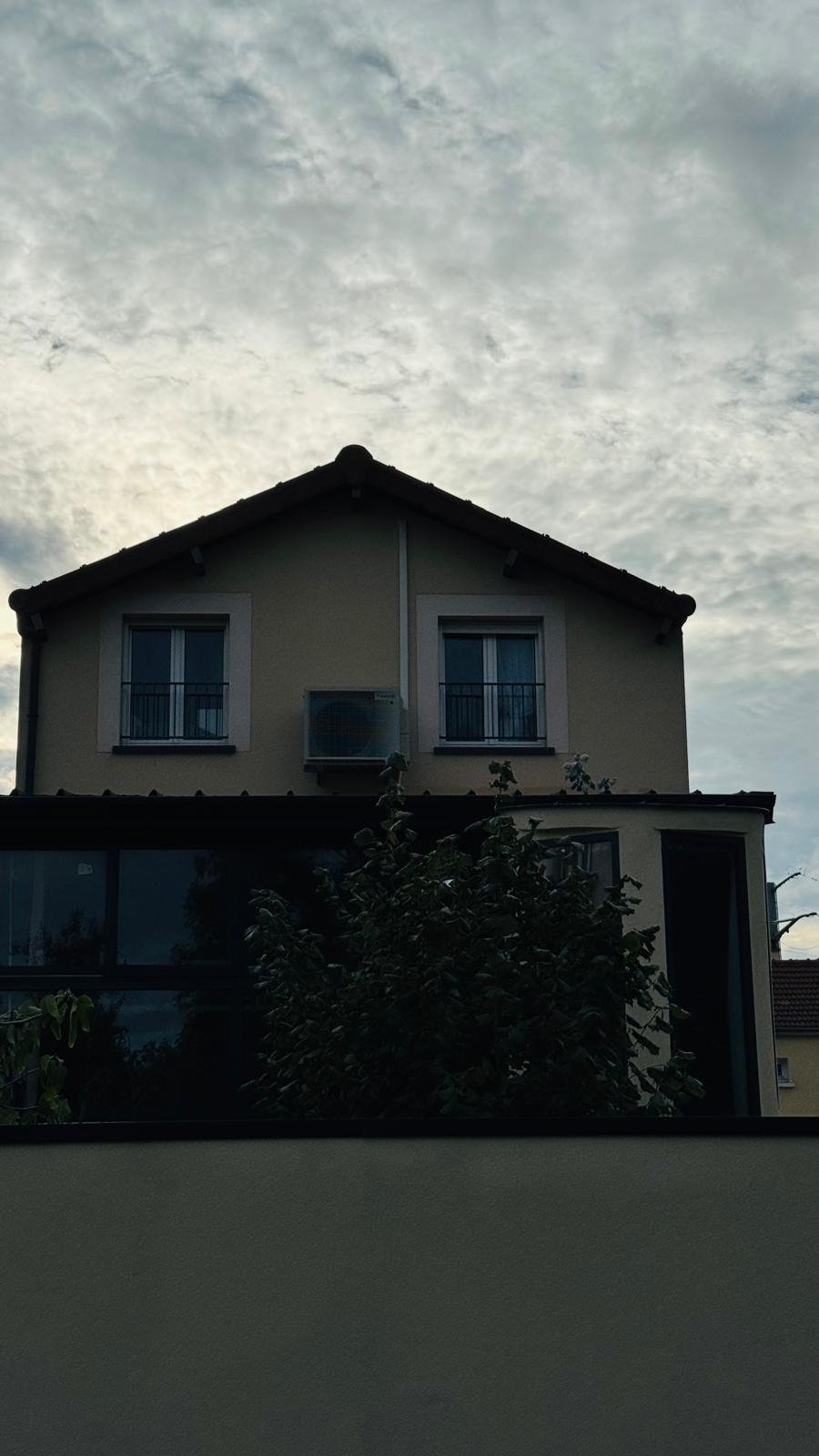 Unité extérieure de climatisation installée en façade d'une maison individuelle